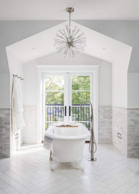 Freestanding tub and french-doors opening to backyard